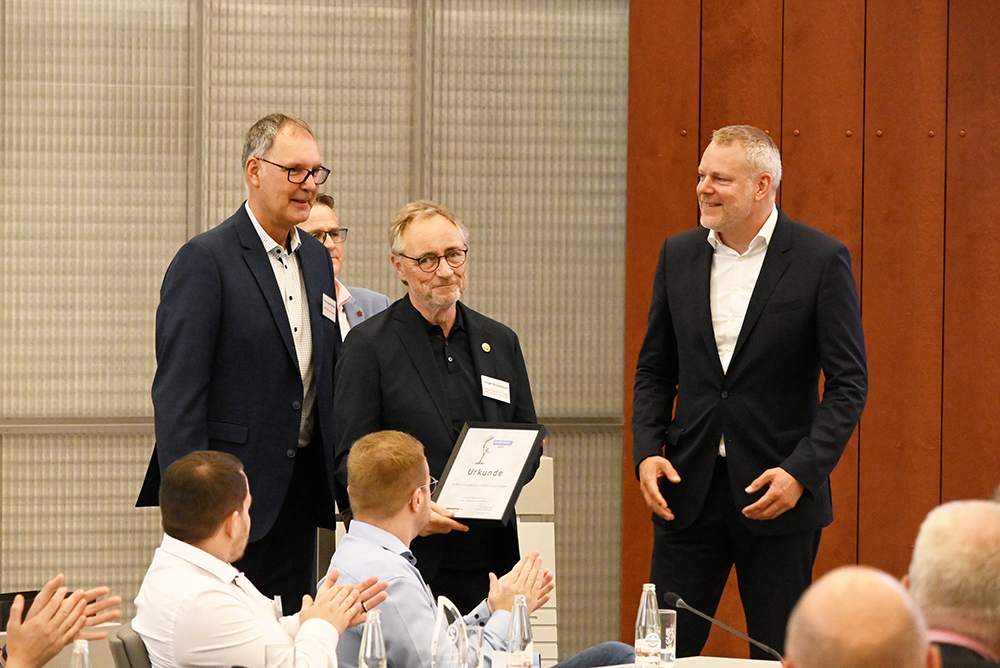 Applaus im Forum: Landrat Dr. Andreas Coenen (r.) und Jobcenter-Geschäftsführer Franz-Josef Schmitz (l.) überreichen Stiftungs-Vorstand Jürgen Brockmeyer die Urkunde.