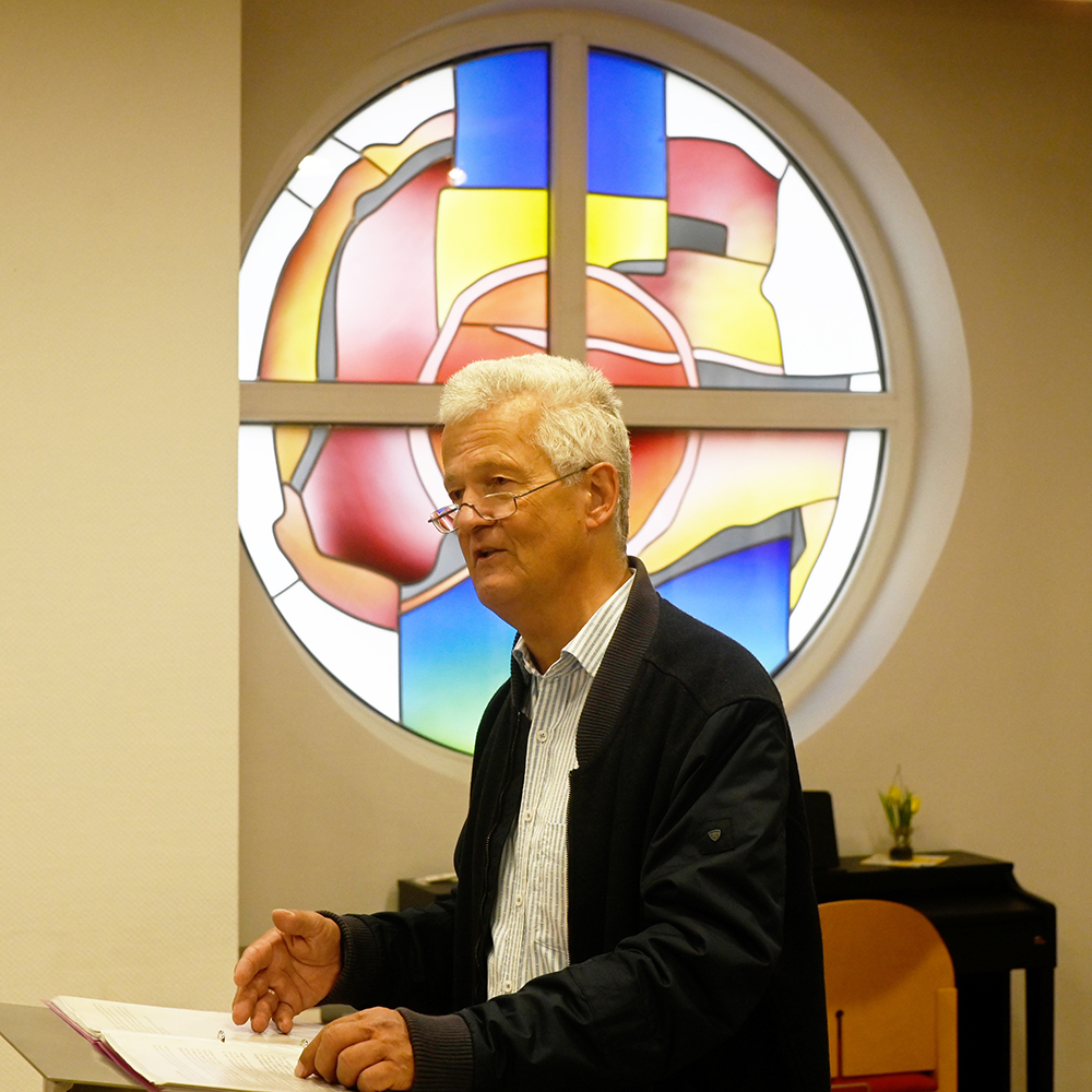 Kulturelles Highlight im St. Peter-Stift: Hinrich Kley-Olsen rezitiert aus dem umfangreichen Werk von Hanns Dieter Hüsch für die Bewohnerinnen und Bewohner der Pflegeeinrichtung. Im Hintergrund die Kapelle, die Zwischenwand zum St. Peter-Café ist für die Lesung geöffnet worden. Kein Platz bleibt frei, es müssen zusätzliche Stühle bereitgestellt werden.