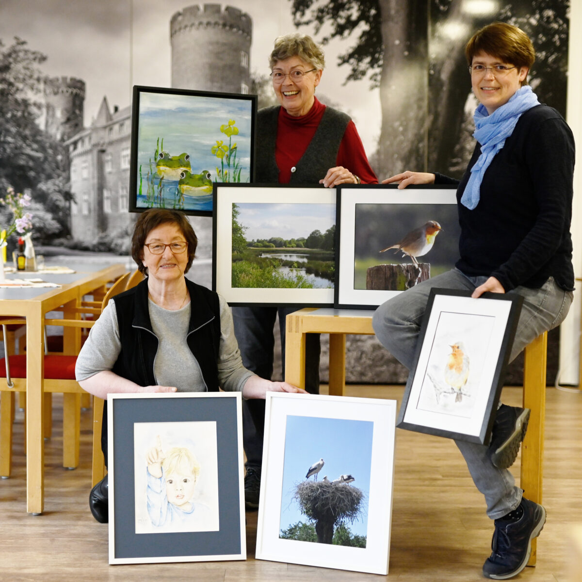Zeigt her eure Bilder: Monika Schwital, Anneliese und Barbara Stoffels (von links) zeigen im St. Peter-Café kurz vor der Aufhängung eine Auswahl ihrer Bilder, die bis Ende Juni im St. Peter-Stift zu sehen sind.